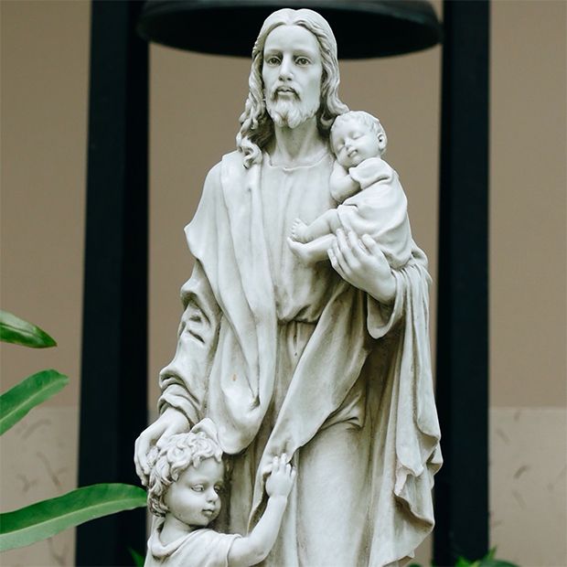 Statue of Jesus Christ holding a child, showing His great love for all humankind.