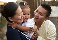 Two loving Mongolian parents doting on their baby girl.