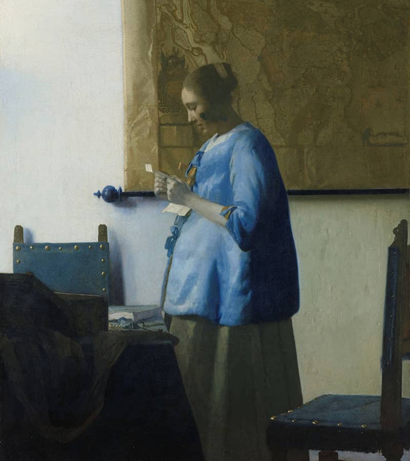 A woman in blue reads a letter