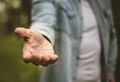 Photo of a man's outstretched hand offering help.