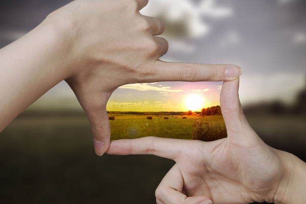 A sunset framed by two hands