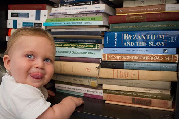 Baby standing by a bookshelf