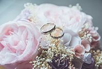 A pair of wedding rings resting on pink flowers